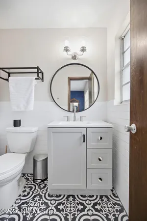 a bathroom with a sink a toilet and a mirror
