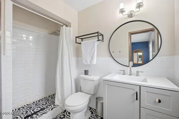 a bathroom with a sink a mirror a toilet and a shower