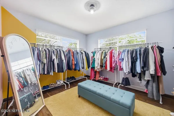 a view of walk in closet with clothes and shoes