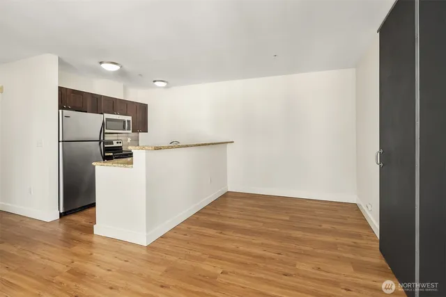 a view of a kitchen with wooden floor and electronic appliances