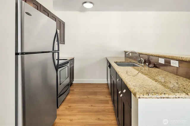 a kitchen with granite countertop a sink and a stove