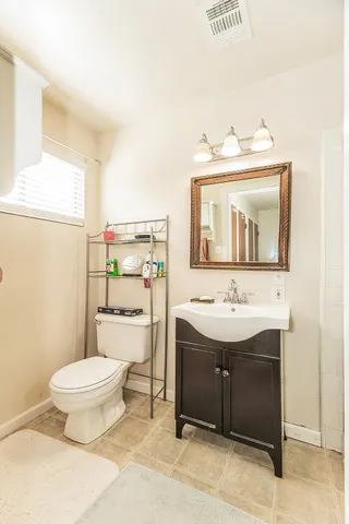 a bathroom with a toilet sink and mirror