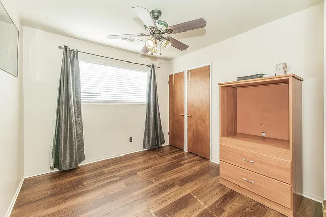 a view of a livingroom with wooden floor and a ceiling fan