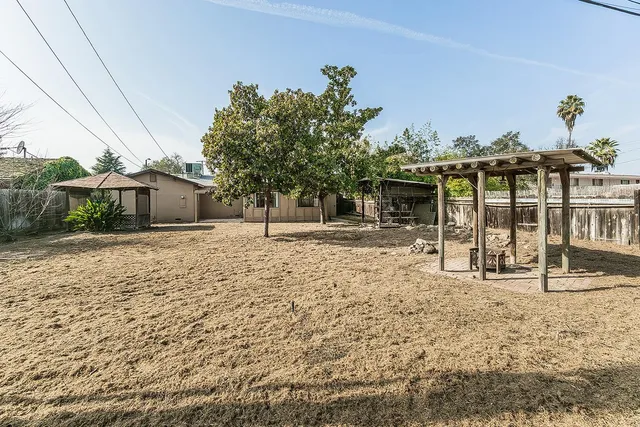 a backyard of a house with table and chairs