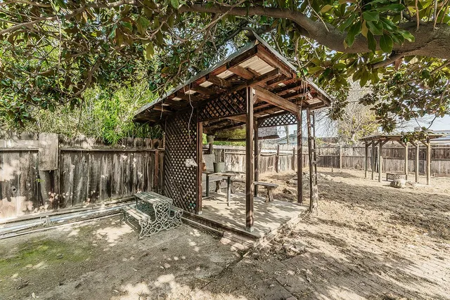 a view of a small yard in front of a house with a large tree