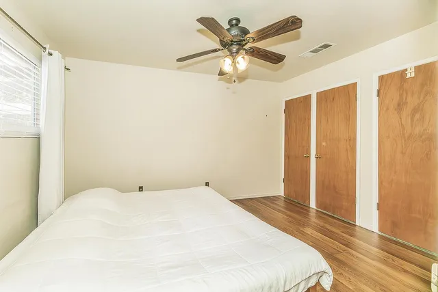 a bedroom with a large bed and a chandelier