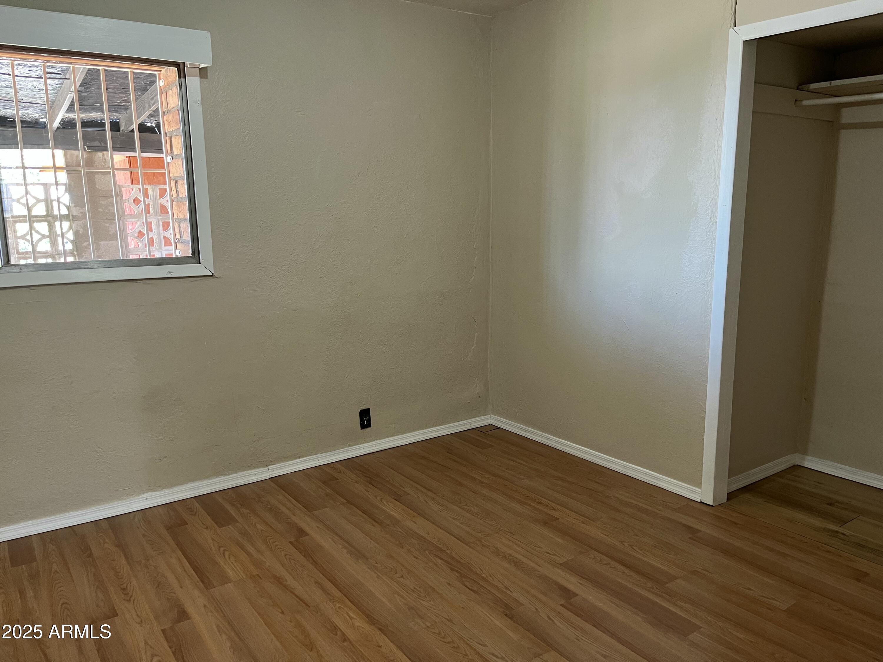 1324 6th Green Street Douglas, AZ 85607 - Photo 11 of 20 a view of an empty room with wooden floor and a window