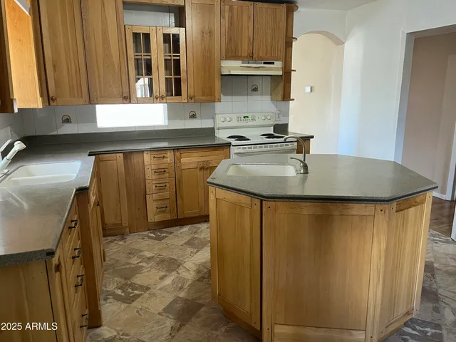a kitchen with sink a refrigerator and a stove