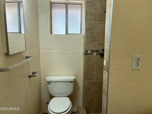 a bathroom with a toilet and a shower