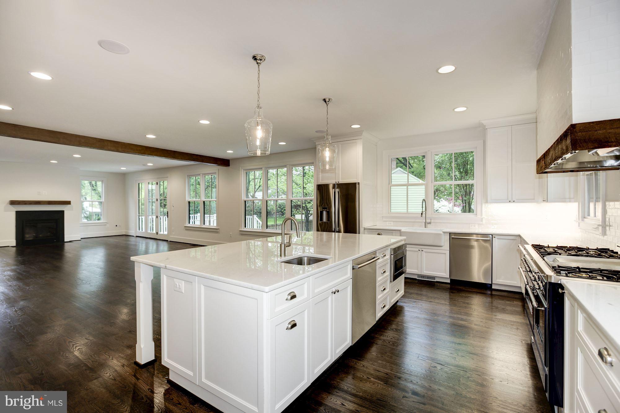 3030 North Stuart Street Arlington, VA 22207 - Photo 5 of 29 a large white kitchen with a stove top oven a sink a dining table and chairs