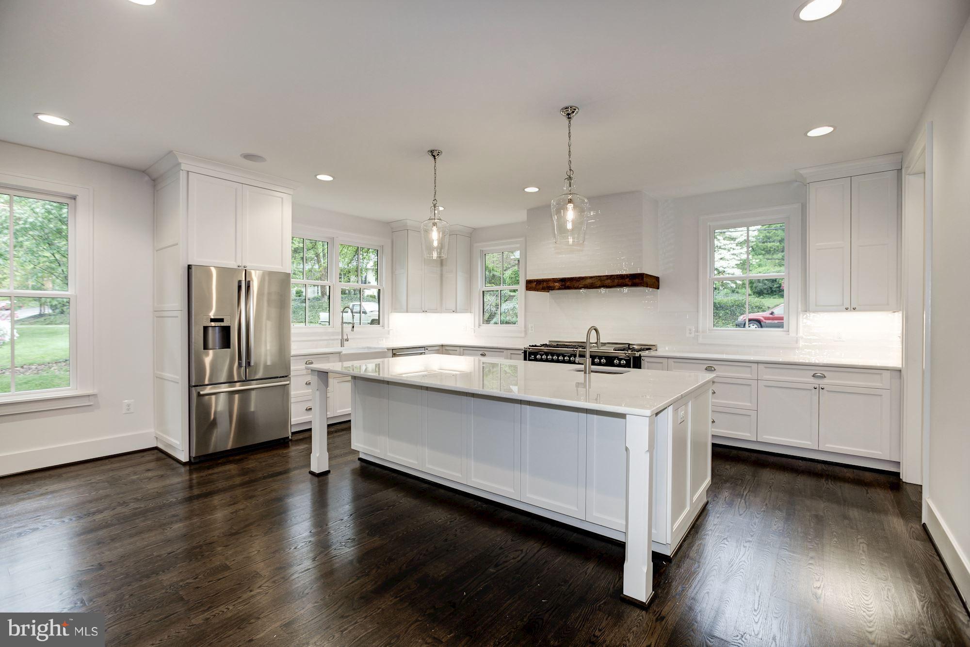 3030 North Stuart Street Arlington, VA 22207 - Photo 8 of 29 a kitchen with stainless steel appliances white cabinets a sink a stove a refrigerator and wooden floor