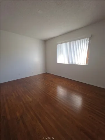 an empty room with wooden floor and windows in it