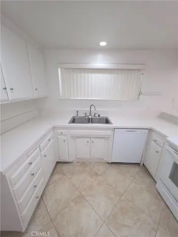 a kitchen with white cabinets a sink and dishwasher