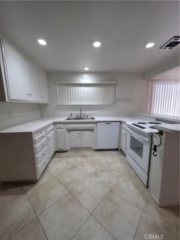 a kitchen with a stove sink and cabinets