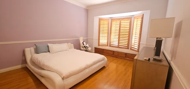 a large bed sitting in a bedroom next to a window