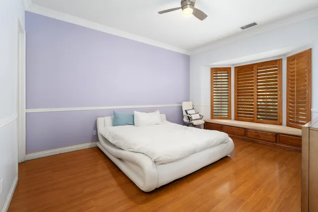 a bedroom with a bed wooden floor and window