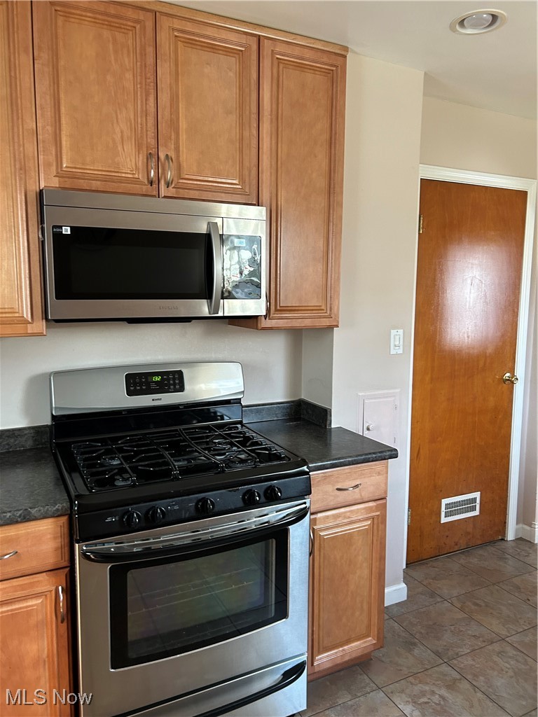 1094 Plainfield Road Cleveland, OH 44121 - Photo 11 of 41 Kitchen featuring light tile patterned floors and stainless steel range oven