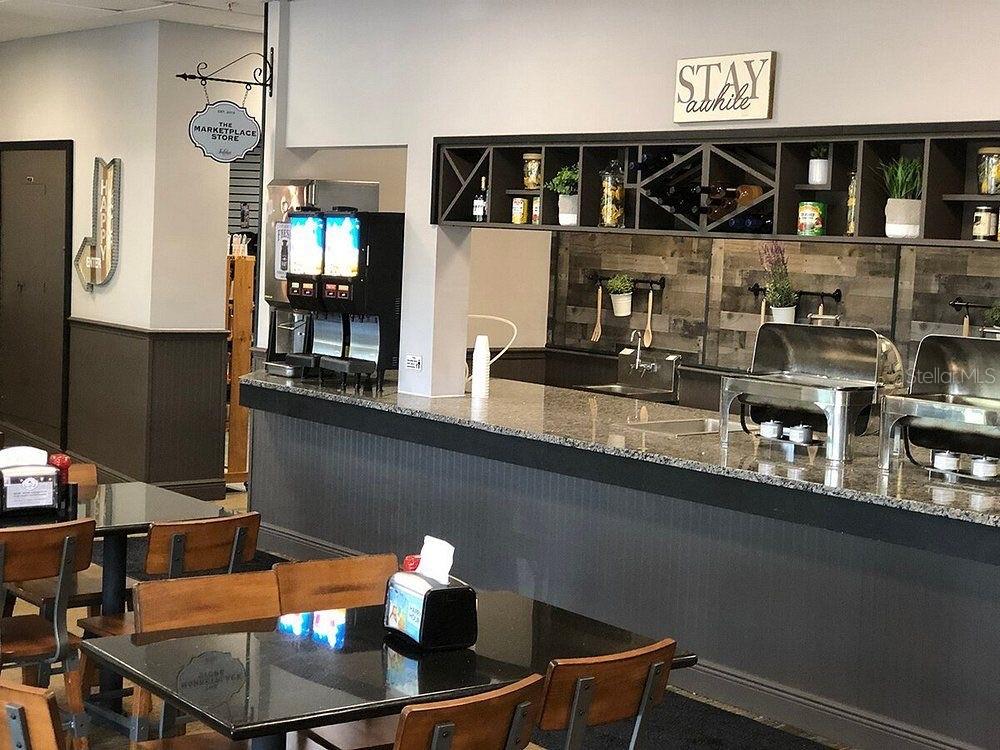 6165 Carrier Drive, Unit 1114 Orlando, FL 32819 - Photo 27 of 31 a kitchen with a table chairs and cabinets