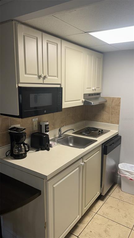 6165 Carrier Drive, Unit 1114 Orlando, FL 32819 - Photo 6 of 31 a kitchen with a sink and cabinets