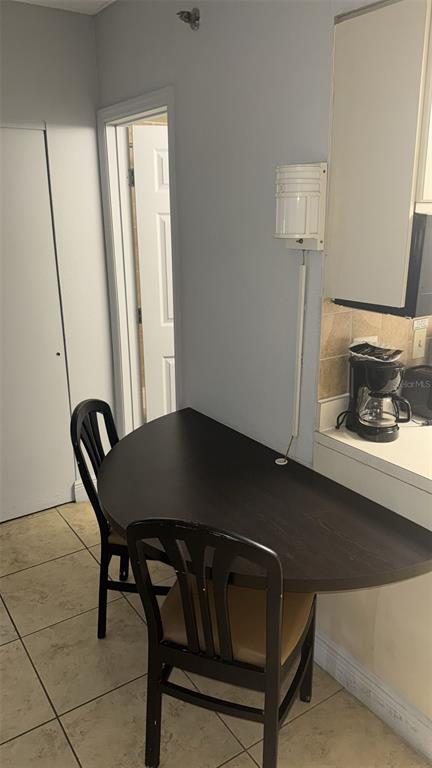 6165 Carrier Drive, Unit 1114 Orlando, FL 32819 - Photo 7 of 31 a living room with a table chairs and a window