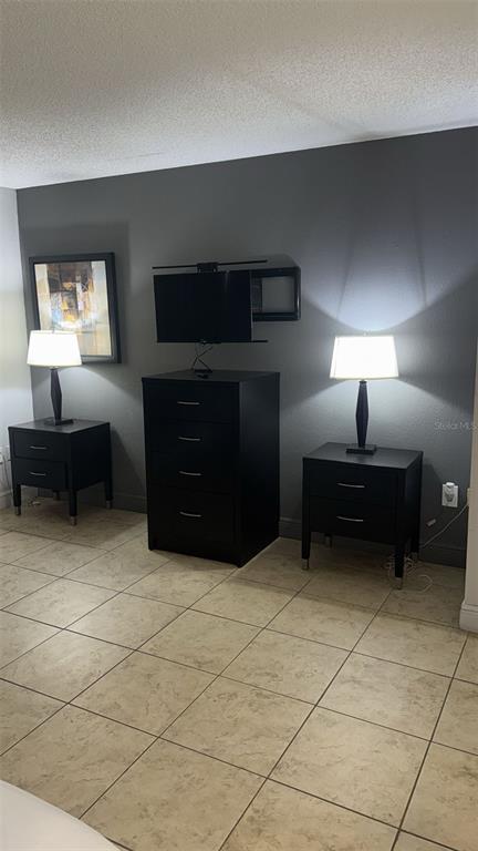 6165 Carrier Drive, Unit 1114 Orlando, FL 32819 - Photo 10 of 31 a living room with furniture and a lamp