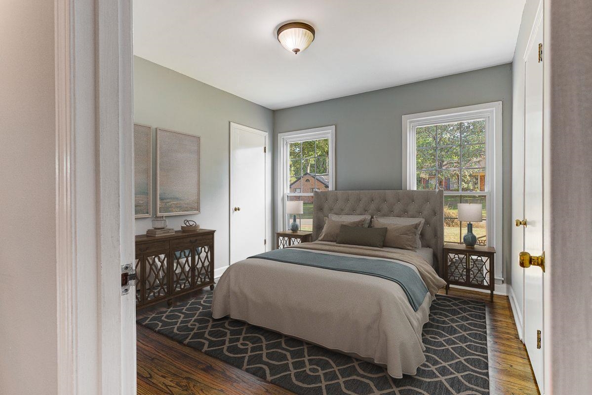 5676 Barfield Road Memphis, TN 38120 - Photo 11 of 23 Bedroom featuring wood-finish flooring, two large windows, a ceiling-mounted light fixture, and two white doors