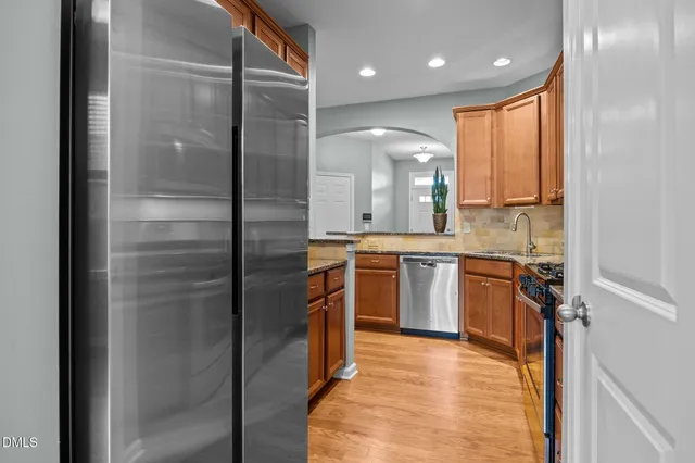 a kitchen with stainless steel appliances granite countertop a refrigerator and a sink