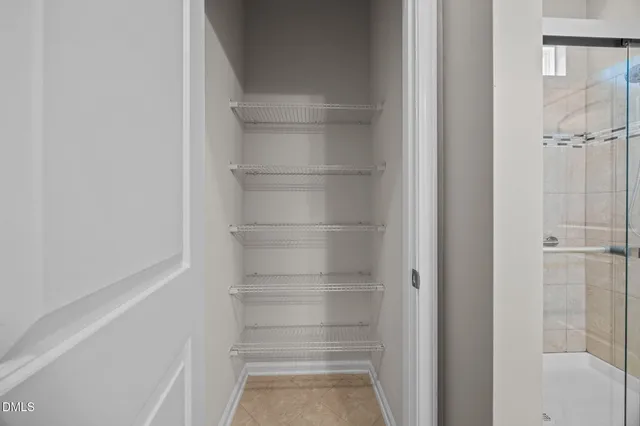 a view of walk in closet with empty racks