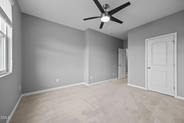 an empty room with fan and windows