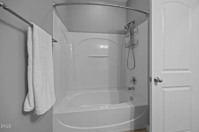 a bathroom with a bath tub with a shower