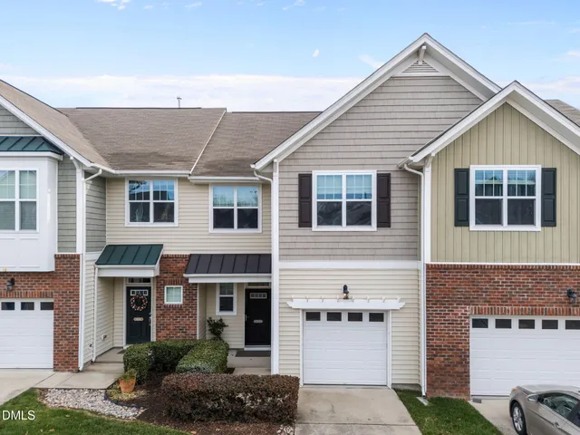 a view of a house with a yard and potted plants