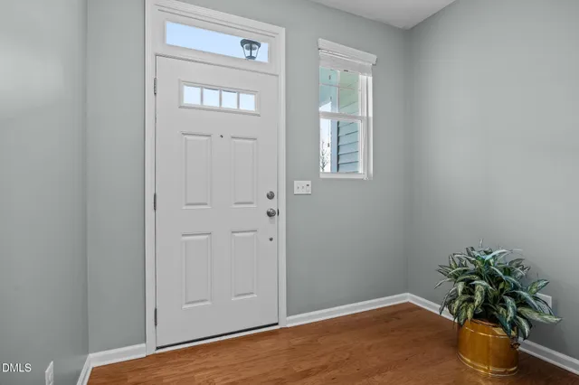 an empty room with window and wooden floor