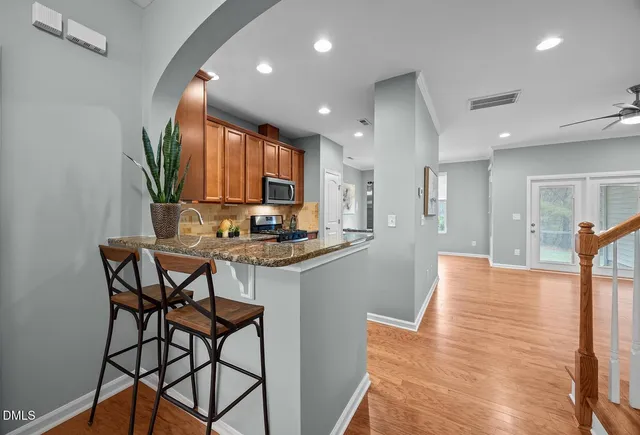 a kitchen with stainless steel appliances kitchen island granite countertop a table and chairs in it
