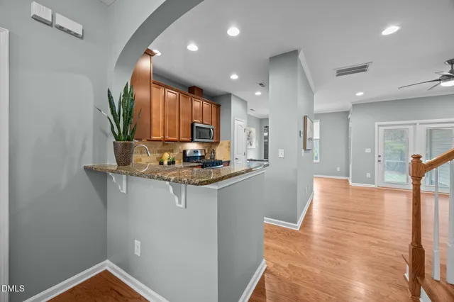 a view of kitchen and kitchen with granite countertop wooden floor
