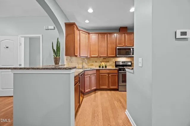 a kitchen with stainless steel appliances granite countertop a stove a sink and a refrigerator