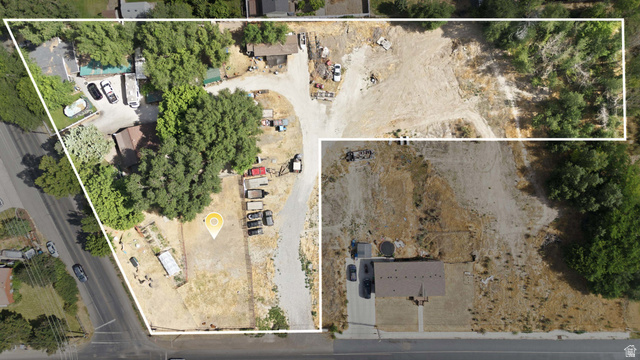 426 North Locust Avenue Lindon, UT 84042 - Photo 6 of 9 Expansive land parcel featuring a central gravel driveway, mature trees providing natural shading, and a combination of cleared and partially treed areas