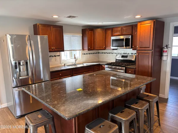a kitchen with stainless steel appliances granite countertop a sink refrigerator and microwave