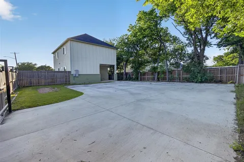 a view of a house with a yard and large tree