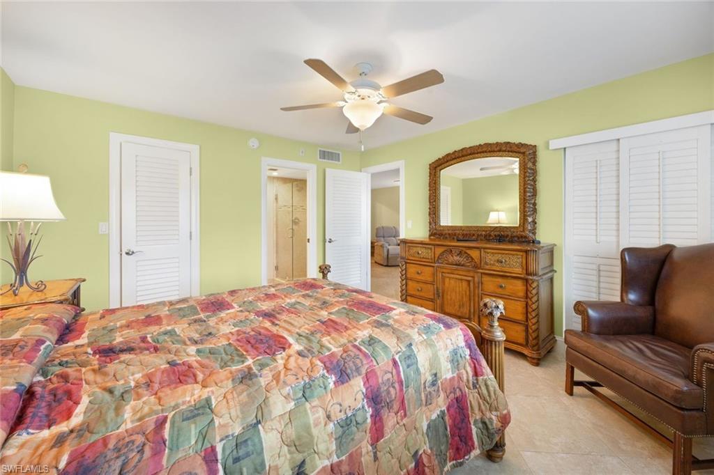41 High Point Circle South, Unit 107 Naples, FL 34103 - Photo 14 of 29 a bedroom with a bed and dresser with mirror