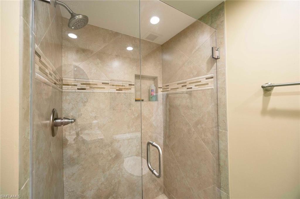 41 High Point Circle South, Unit 107 Naples, FL 34103 - Photo 17 of 29 a bathroom with a glass shower door