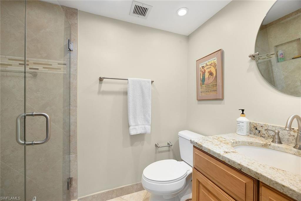 41 High Point Circle South, Unit 107 Naples, FL 34103 - Photo 18 of 29 a bathroom with a granite countertop sink toilet and shower