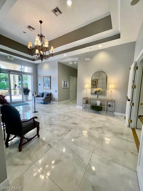 41 High Point Circle South, Unit 107 Naples, FL 34103 - Photo 25 of 29 a living room with furniture a chandelier and a dining table