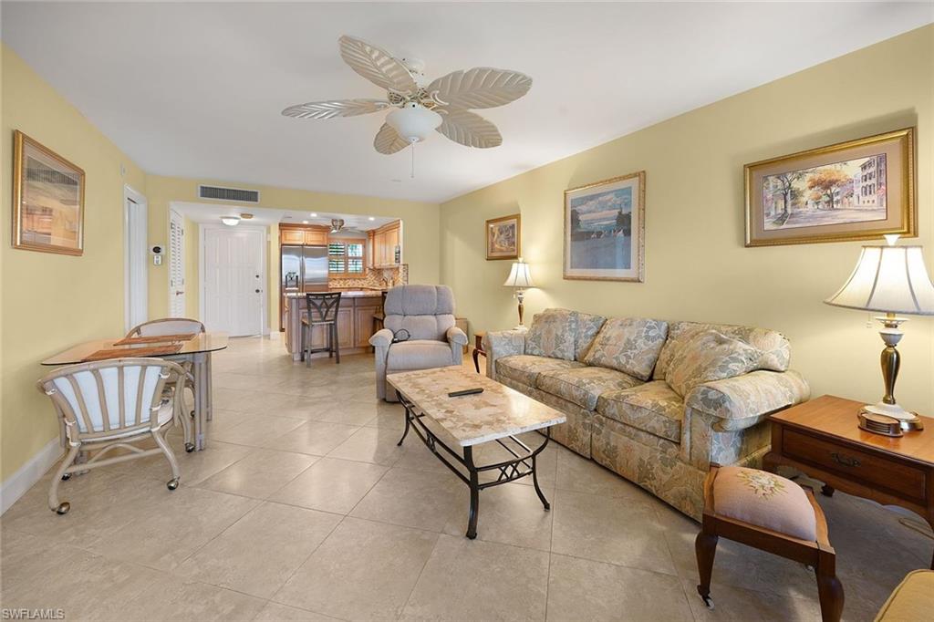 41 High Point Circle South, Unit 107 Naples, FL 34103 - Photo 6 of 29 a living room with furniture and a large window