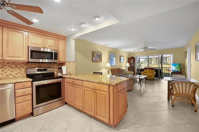 a kitchen with stainless steel appliances granite countertop a refrigerator a stove top oven a sink and dishwasher