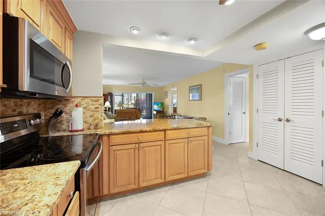 a kitchen with stainless steel appliances granite countertop a kitchen island a stove a table and chairs