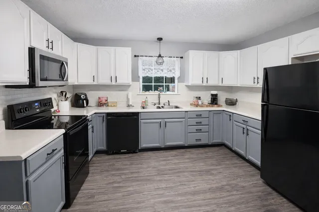 a kitchen with a sink a stove a refrigerator and cabinets