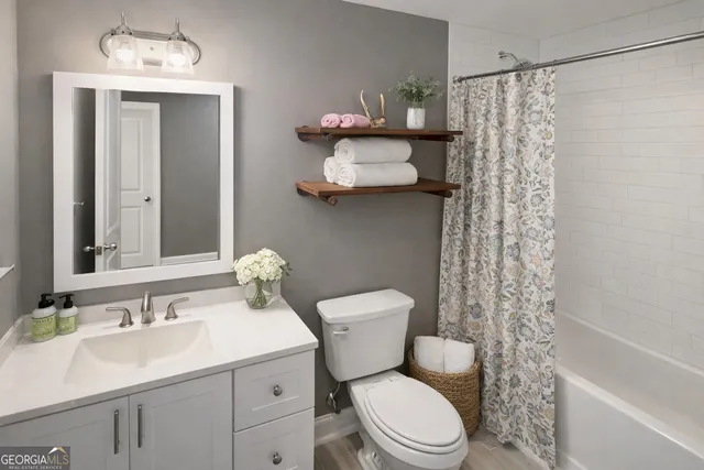 a bathroom with a sink toilet mirror and shower