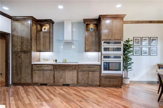 a kitchen with stainless steel appliances granite countertop a refrigerator and a stove top oven