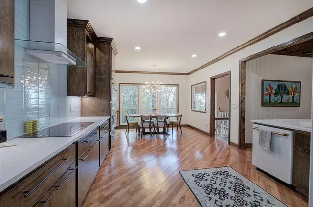 a dining room with furniture large windows and a chandelier