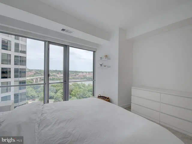 a bedroom with a bed and a large window